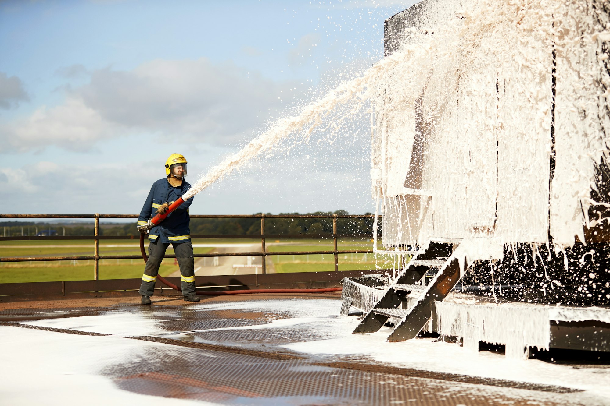 Firemen training, fireman spraying firefighting foam at training facility